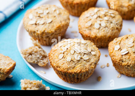 Vegano sano oat muffin, mela e banana torte su una piastra bianca. Sfondo blu. Foto Stock