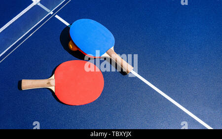 Tavolo da ping pong. Due racchette di colore rosso e blu giacciono su un tavolo blu. Il concetto di uno stile di vita sano e sportivo. Spazio di copia Foto Stock