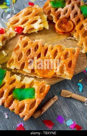 Angolo di alta vista di alcuni pezzi di una coca de Sant Joan, un tipico dolce torta piatta dalla Catalogna, Spagna, mangiato su Saint Johns Eve, su un tavolo rustico, n Foto Stock