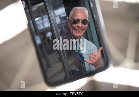 10 maggio 2019, Assia, Frankfurt/Main: Peter Wirth, noto come 'Bahnbabo', guarda nello specchio retrovisore di un tram. Il 57-anno-vecchio da Francoforte ha lavorato per VGF-Verkehrsbetriebe come un tram driver per più di trent'anni. Per alcuni anni la ben addestrato l uomo ha avuto lo status di culto, soprattutto tra i giovani e i social media. Foto: Boris Roessler/dpa Foto Stock