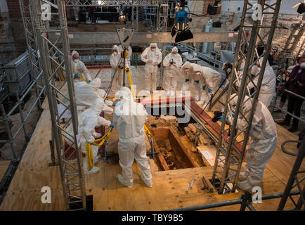 Mainz, Germania. 04 Giugno, 2019. Il team di ricerca solleva il coperchio di sarcofago. Nella navata centrale del protestante del San Johanniskirche in Mainz, la vecchia cattedrale, straordinariamente ben conservato sarcofago è stato scoperto. Il sarcofago, stimato a 1.000 anni, è aperto in presenza dei mezzi di comunicazione e un team di ricerca internazionale. Credito: Andreas Arnold/dpa/Alamy Live News Foto Stock