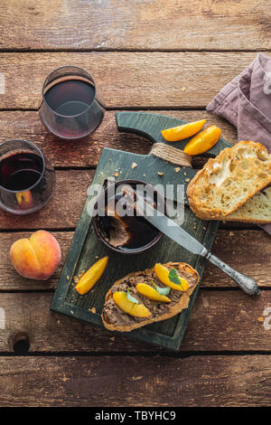 Di fegato di pollo con patè griiled pane e pesche, di stile rustico. Foto Stock