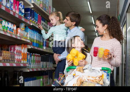 Ordinario felici i clienti americani con i bambini la selezione di dolci prodotti lattiero-caseari in ipermercati Foto Stock