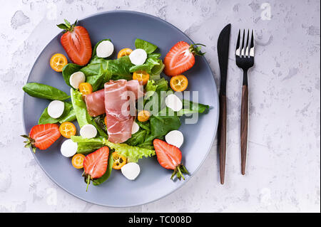 Delizioso con insalata di verdure, carni bovine, fragole, grumi e mozzarella. Gustosi e sani. Il cibo italiano. Vista superiore Foto Stock