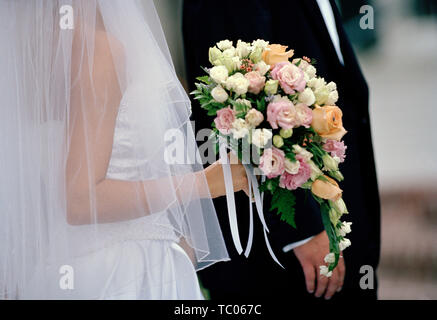 Sposa e lo sposo insieme il giorno delle nozze con un bouquet di fiori. Foto Stock