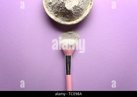 Argilla cosmetici con spazzola sul colore di sfondo Foto Stock