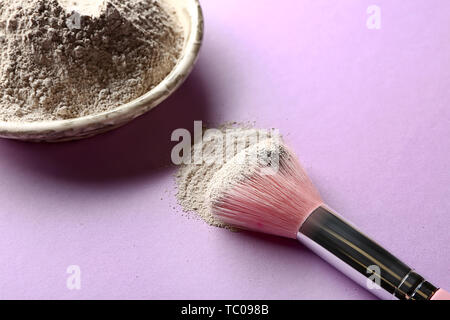 Argilla cosmetici con spazzola sul colore di sfondo Foto Stock