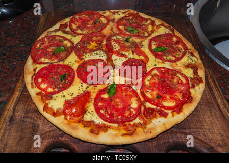 La Pizza. Italiani freschi napoletano, basilico e pomodoro su un tavolo di legno Foto Stock