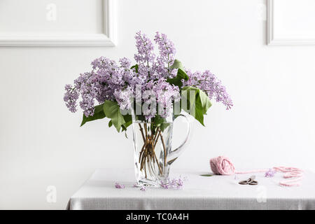 Vaso con bellissimi fiori lilla sul tavolo in camera Foto Stock