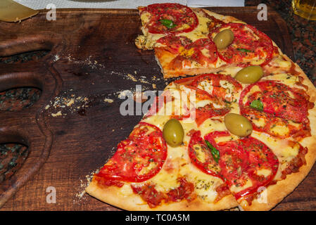 La Pizza. Italiani freschi napoletano, basilico e pomodoro su un tavolo di legno Foto Stock