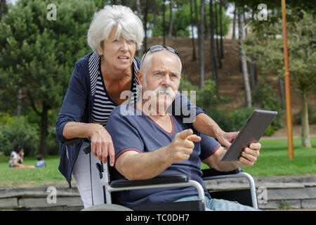 Donna e uomo senior in carrozzella Foto Stock