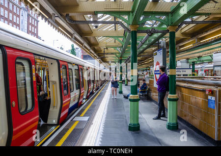 Un treno attende presso la piattaforma a South Kensington Stazione della metropolitana di Londra. Foto Stock