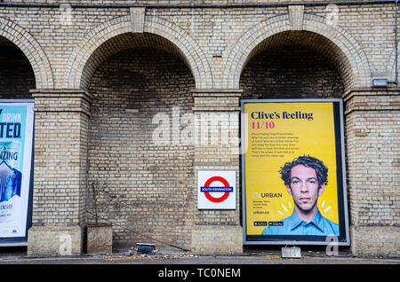 Un pannello pubblicitario sotto un'arcata su una piattaforma che non è più utilizzato a South Kensington Stazione della metropolitana di Londra Foto Stock