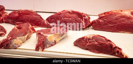 Concetto di carne. Carne di manzo crudo in grossi pezzi a Butcher Shop pronto per essere venduto. Carne di vitello cruda closeup, banner. Foto Stock