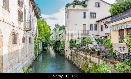 La città di Portogruaro in Veneto Italia con il fiume Lemene e case Foto Stock
