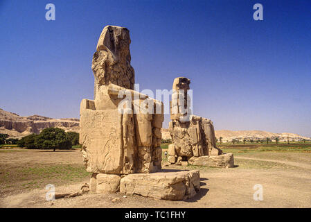 Luxor, Egitto. I Colossi di Memnon, due enormi statue di pietra del faraone Amenhotep III in piedi nella necropoli tebana sulla sponda ovest del Foto Stock