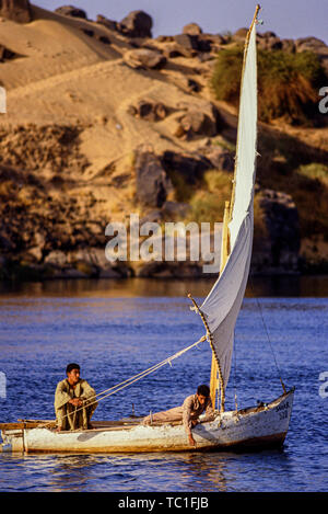 Luxor, Egitto. Due ragazzi navigano le loro piccole felucca barche a vela sul fiume Nilo. Foto: © Simon Grosset. Archivio: immagine digitalizzata dalla un originale transpa Foto Stock