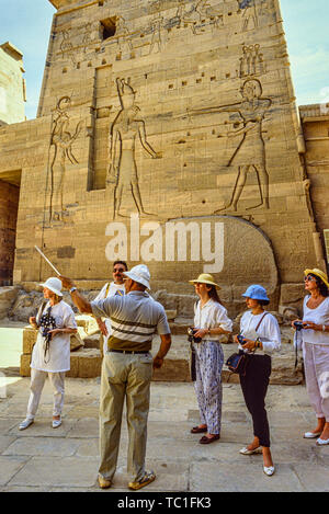 Egitto: turisti e una guida al Tempio di Philae sul fiume Nilo. Foto: © Simon Grosset. Archivio: immagine digitalizzati da un originale di trasparenza. Foto Stock