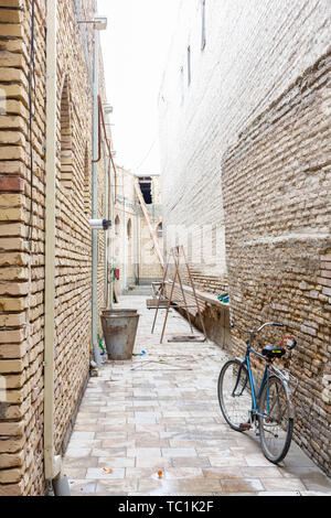 Nero retro vintage bicicletta con il vecchio muro di mattoni e una copia dello spazio. Bicicletta retrò con cestino davanti al vecchio muro in mattoni. Retrò bicicletta su strada wi Foto Stock