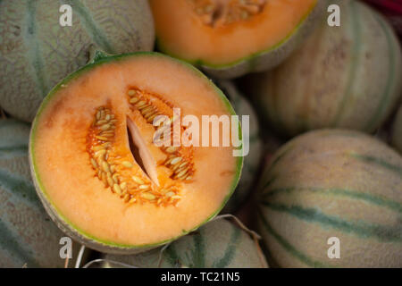 Aprire il taglio di melone Charentais sulla pila di mercato Foto Stock