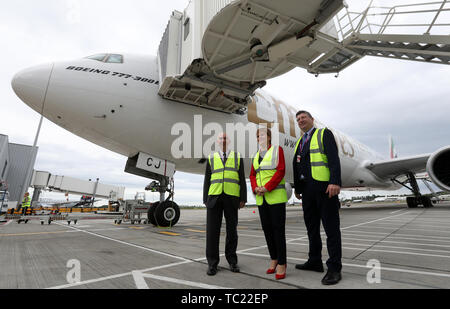 Primo Ministro Nicola Sturgeon con Sir John Elvisge (a sinistra), Presidente dell'aeroporto di Edimburgo insieme all'Amministratore Delegato Gordon Dewar sulla asfalto dell'aeroporto di Edimburgo, mentre apre ufficialmente un'espansione del terminal. £80 milioni sono stati investiti nell'espansione del terminal che ha fornito nuove sale arrivi internazionali e nazionali e aree di ritiro bagagli, nuovi cancelli e aree salotto, nuovi stand aerei, nuove sale e nuovi punti vendita al dettaglio e di cibo e bevande. Foto Stock