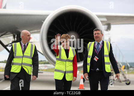 È sotto embargo per 0001 Mercoledì 5 giugno. Primo Ministro Nicola Storione con Sir John Elvidge (sinistra), Presidente dell'aeroporto di Edimburgo a fianco di Chief Executive Gordon Dewar su asfalto all'aeroporto di Edimburgo come lei si apre ufficialmente un terminale di espansione. £ 80 milioni di euro sono stati investiti nell'espansione terminale che ha fornito nuovi Internazionale e Nazionale di sale Arrivi e Ritiro bagagli aree, nuove porte e aree salotto, nuovo stands aeromobili, nuovi salotti e nuovi retail e punti vendita di cibo e bevande. Foto Stock