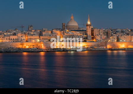 Vista panoramica sullo skyline di La Valletta al bel tramonto da Sliema con le chiese di Nostra Signora del Monte Carmelo e di san Paolo Pro-Cathedral anglicana, va Foto Stock