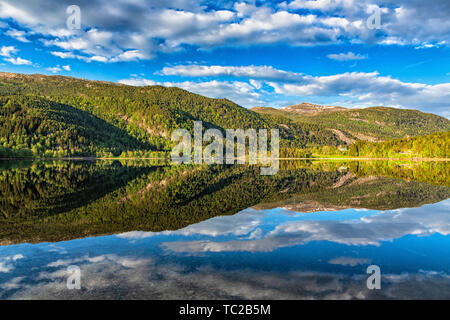 Piccolo villaggio vicino al lago in Hordaland, Norvegia. Foto Stock