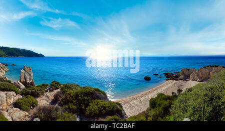 Mattinata estiva sunshiny spiaggia sabbiosa e rocciosa costa vicino a Spiaggia Platanitsi, penisola di Sithonia, Chalcidice, Grecia Foto Stock