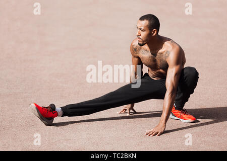 Uomo muscolare Stretching il suo corpo dopo il corso di formazione Foto Stock