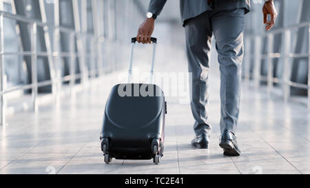 Imprenditore all'Aeroporto spostando al terminale Gate per viaggio di lavoro Foto Stock