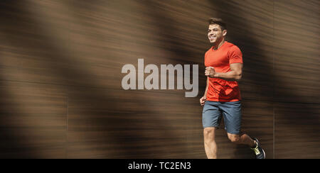 Felice fit uomo correre all'aperto al mattino Foto Stock