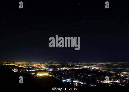 Plain illumina parzialmente coperta dalla nebbia, luci soffuse. Monte Grappa, paesaggio italiano Foto Stock