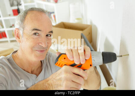 Uomo maturo utilizzando giraviti a casa Foto Stock