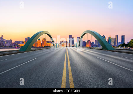 Shanghai skyline della città e di asfalto vuota autostrada al tramonto Foto Stock