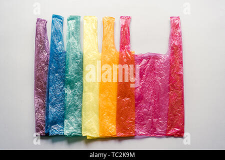 Sacchetti di plastica impilate nei colori dell'arcobaleno. Ecologia promemoria. Società di consumo. Immagine concettuale. Foto Stock