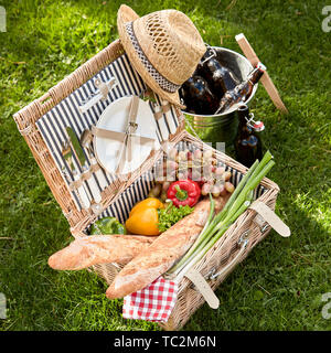 Salute vegetariano e vegano pranzo picnic con insalata fresca ingredienti e baguette francesi impaccato in un ostacolare in vimini a fianco di un argento wine cooler Foto Stock