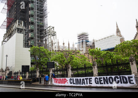 Londra, Regno Unito. Il 4 giugno, 2019. Un banner al di fuori del Palazzo di Westminster legge 'Trump: Clima genocidio'. Migliaia di cambiamenti climatici attivisti, gruppi di donne, studenti, pacifisti, i sindacalisti e le famiglie si sono riuniti per un insieme contro Trump "Carnevale di resistenza" contro la visita di Stato del Presidente americano Donald Trump nel secondo giorno della sua visita di 3 giorni. Una grande operazione di polizia era in posizione per facilitare la protesta ma per impedire l'accesso alle zone immediatamente adiacenti a Downing Street, dove erano i colloqui in corso tra il primo ministro Theresa Maggio e Presidente Trump. Credito: Foto Stock