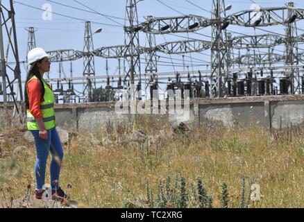 (190605) -- HOMS, 5 giugno 2019 (Xinhua) -- una femmina elettrico è visibile dopo il fissaggio di un alta tensione linea di elettricità nella provincia di Homs, centrale in Siria il 30 maggio 2019. Come la guerra in Siria rumbled on, donne siriano ha iniziato a impegnarsi in più posti di lavoro rispetto ad una normale lavoro di ufficio e di educazione dei figli, come un gran numero di uomini avevano aderito all'esercito o ha lasciato il paese per cercare rifugio. I posti di lavoro che le donne del paese sono sempre più facendo includono la riparazione di automobili, alla guida di autobus o taxi, e ancor più interessante, utilizzando una gru per raggiungere le linee elettriche ad alta tensione e fissarli, malgrado tutte le sfide su Foto Stock