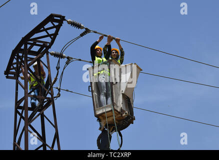 (190605) -- HOMS, 5 giugno 2019 (Xinhua) -- Due donne lavoratori elettrici fissare un alta tensione linea elettrica nella provincia di Homs, centrale in Siria il 30 maggio 2019. Come la guerra in Siria rumbled on, donne siriano ha iniziato a impegnarsi in più posti di lavoro rispetto ad una normale lavoro di ufficio e di educazione dei figli, come un gran numero di uomini avevano aderito all'esercito o ha lasciato il paese per cercare rifugio. I posti di lavoro che le donne del paese sono sempre più facendo includono la riparazione di automobili, alla guida di autobus o taxi, e ancor più interessante, utilizzando una gru per raggiungere le linee elettriche ad alta tensione e fissarli, malgrado tutte le sfide come la famiglia Foto Stock