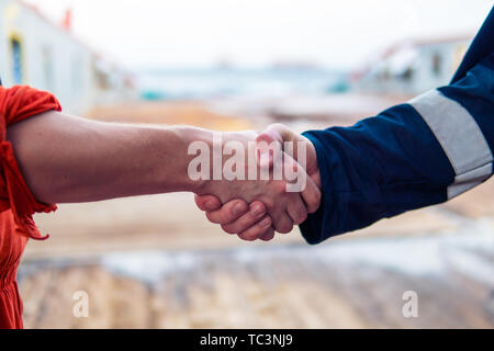 Marine imprenditore aggiudicatario lo handshaking con il lavoratore sulla nave. Foto Stock