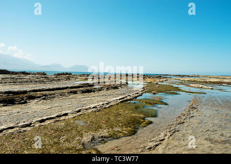 Vuoto spiaggia rocciosa in bluesky Foto Stock