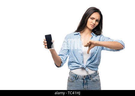 Deluso ragazza con smartphone con schermo vuoto e mostrando il pollice verso il basso isolato su bianco Foto Stock