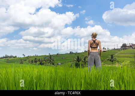 Rilassato e informale donna sportivo godendo di natura pura in splendidi e verdi risaie di Bali. Foto Stock