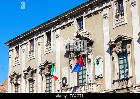 Particolare della facciata anteriore della città storica di Hall in Catania, Sicilia, Italia. Sul balcone si è bandiera italiana sventola bandiera e della città di Catania. Foto Stock