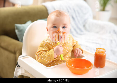 Carino piccolo bambino di mangiare il cibo gustoso a casa Foto Stock