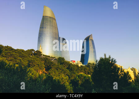 18 Settembre 2017- Baku in Azerbaijan: torri a fiamma al mattino. Vista delle torri popolare dall'alto parco con alberi in primo piano. Foto Stock