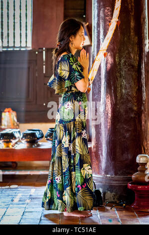 Una giovane donna asiatica si erge e adorava Buddha nel Tempio di Wat Phant Tao Chiang mai, Thailandia. Foto Stock