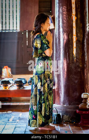 Una giovane donna asiatica si erge e adorava Buddha nel Tempio di Wat Phant Tao Chiang mai, Thailandia. Foto Stock