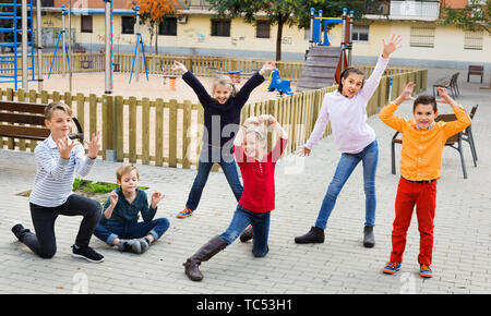 Agendo con gioco allegro positivo ai bambini di prestazioni all'aperto in autunno Foto Stock